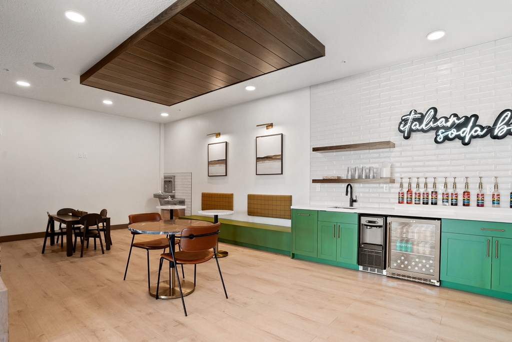 a dining room with a table and chairs and a coffee bar and a refrigerator