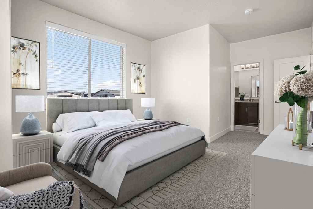 A bedroom with a large bed and a chair.