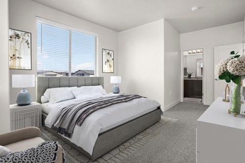 A bedroom with a large bed and a chair.