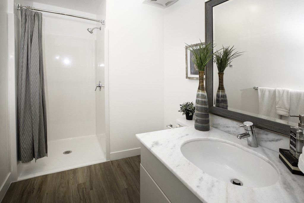 a white bathroom with a sink and a shower