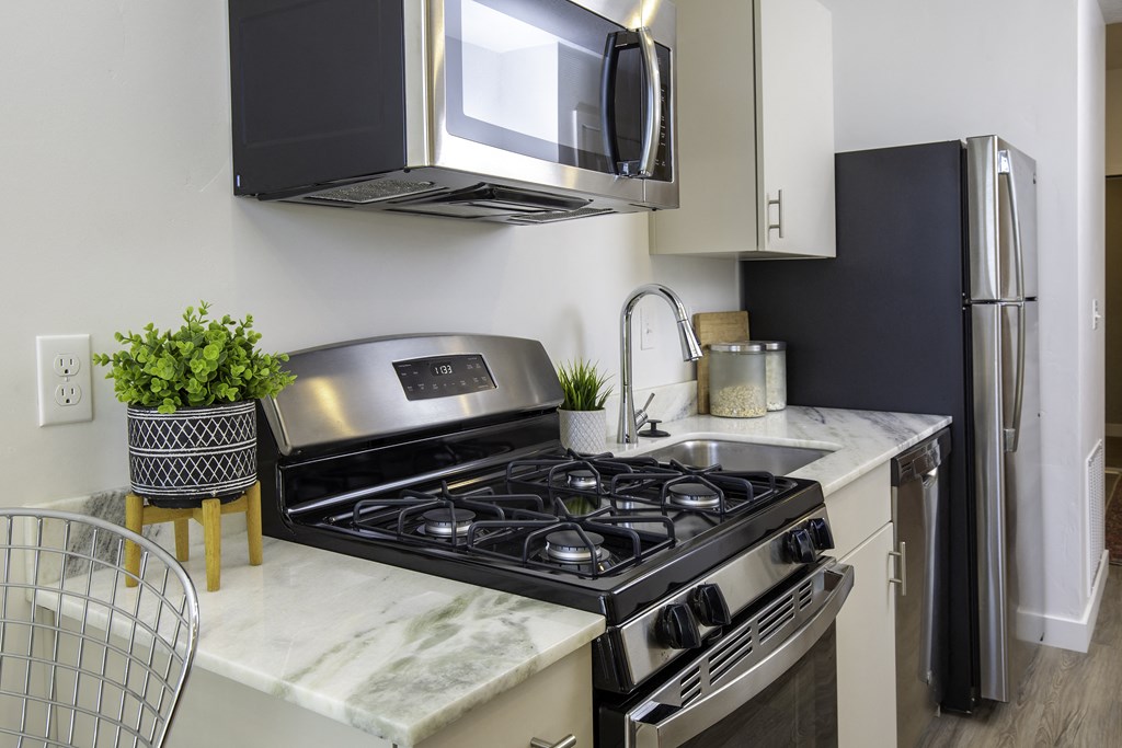 a kitchen with a stove and a microwave and a refrigerator