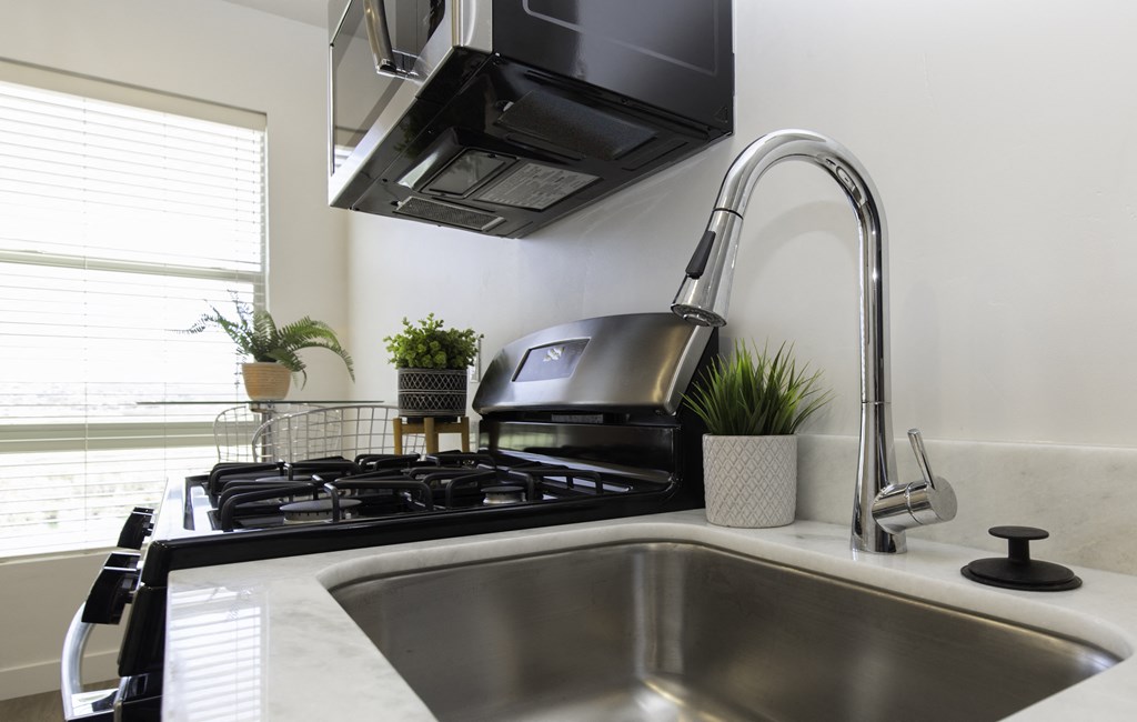a kitchen with a sink and a stove and a microwave