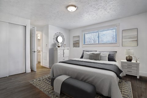 A bedroom with a large bed and a mirror on the wall.