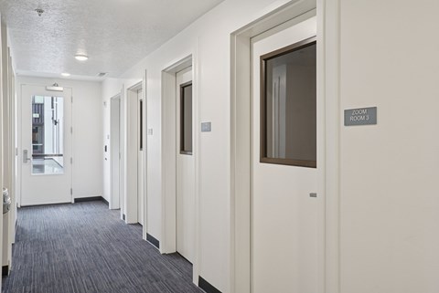 A hallway with doors on both sides and a sign that says "2020 POOL".