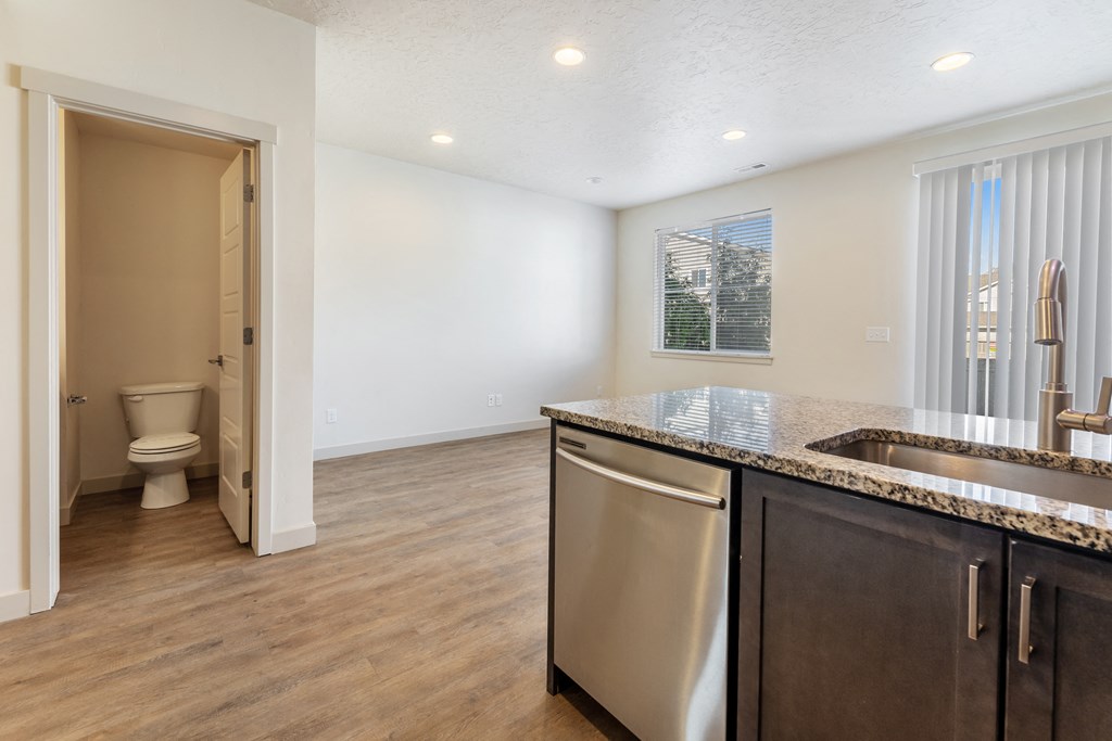 a kitchen with an island and a toilet in the background
