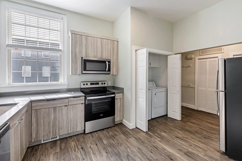 a kitchen with a stove and a refrigerator and a window