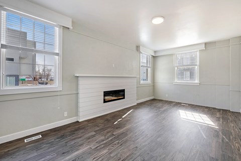 an empty living room with white walls and a fireplace