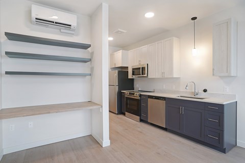 A kitchen with a black refrigerator and a white counter.
