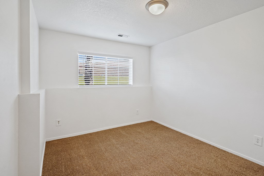 an empty room with white walls and a window