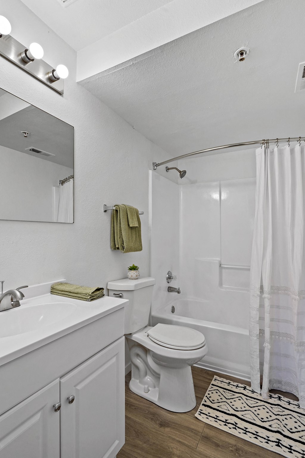 a white bathroom with a shower toilet and sink