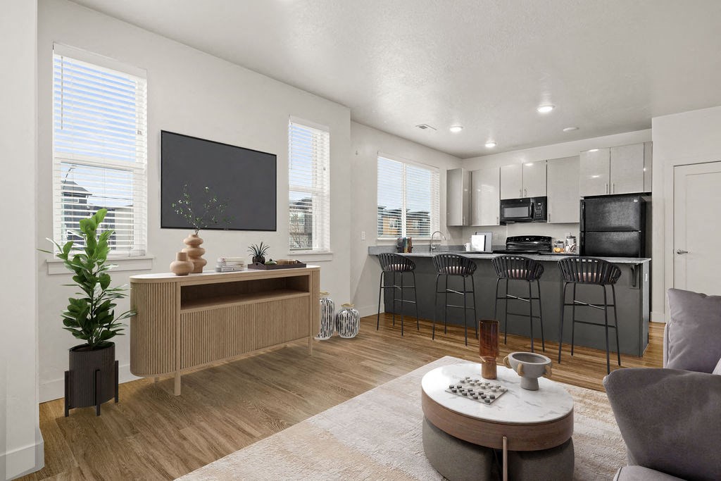 A modern living room with a wooden floor and a grey sofa.