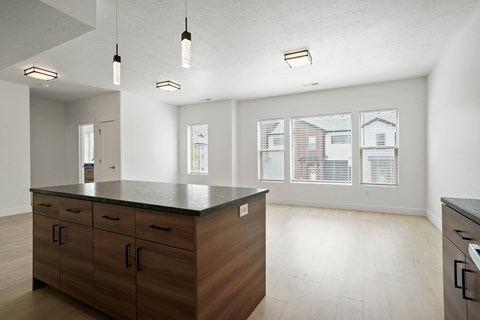 A kitchen with wooden cabinets and a black countertop.