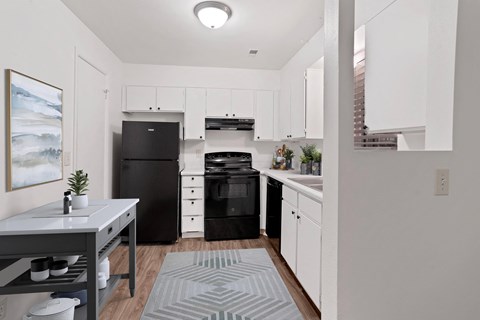 a renovated kitchen with black appliances and white cabinets