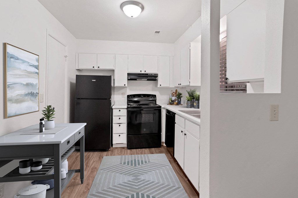 a kitchen with white cabinetry and black appliances