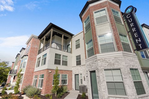 Contemporary apartment building with turret tower and brick facade at Current by Lotus Apartments, Ogden, 84401