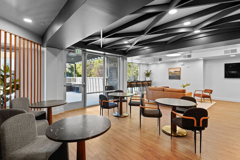 a lounge area with tables and chairs and a pool