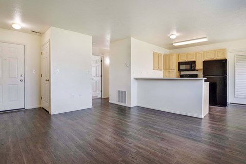A kitchen area with a white counter and a black fridge.