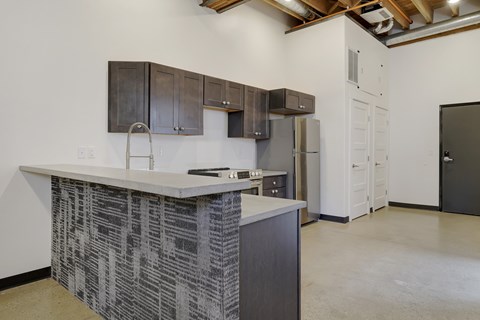 A kitchen with a white counter top and a black and white patterned backsplash.