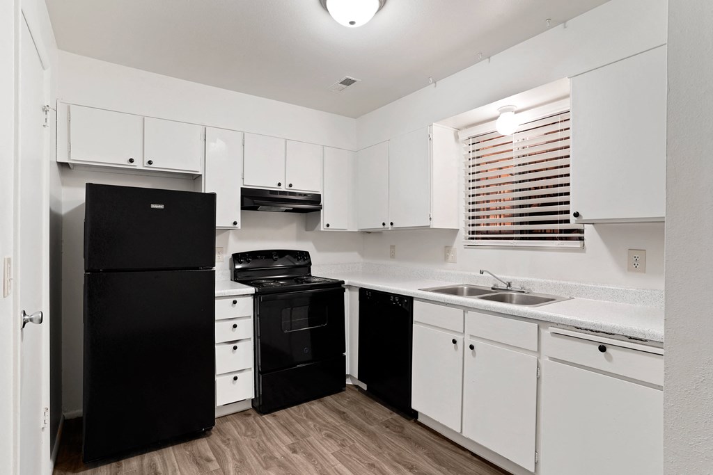 a kitchen with white cabinets and black appliances