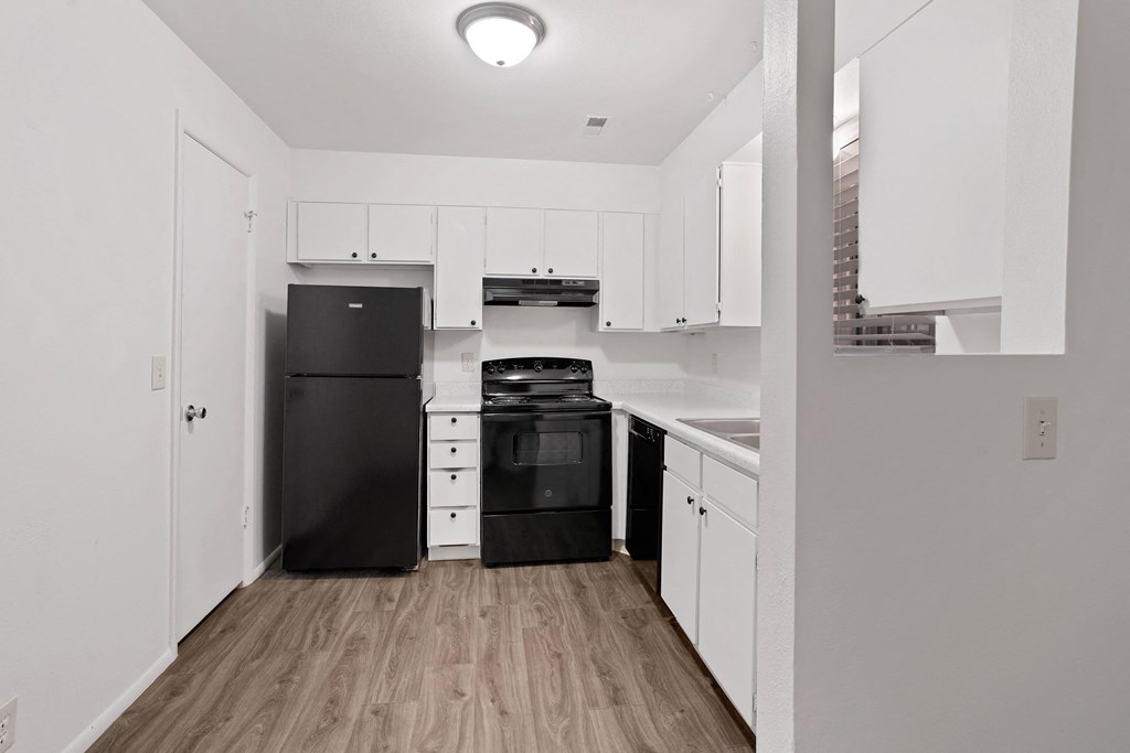 a kitchen with white cabinetry and black appliances
