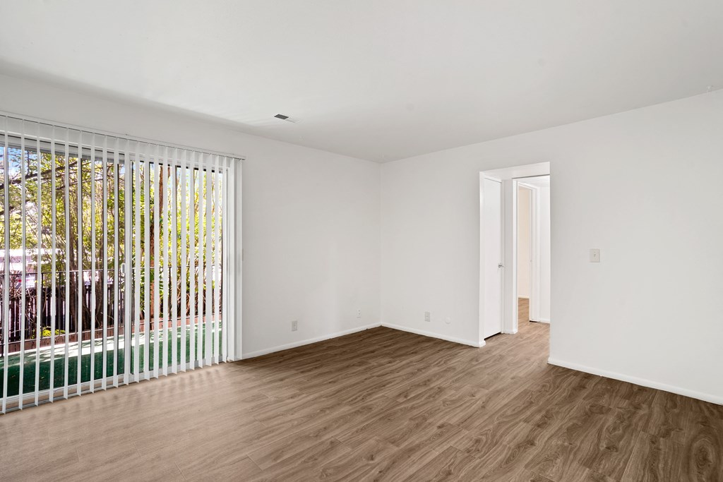 a bedroom with hardwood floors and white walls
