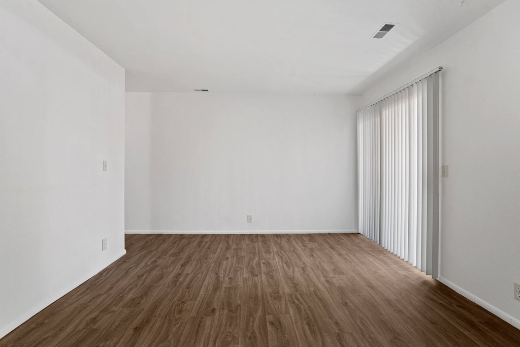 a bedroom with hardwood floors and white walls