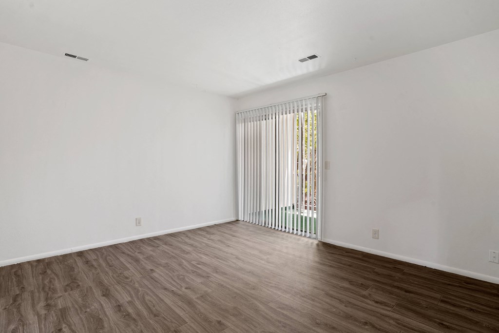 a bedroom with hardwood floors and white walls
