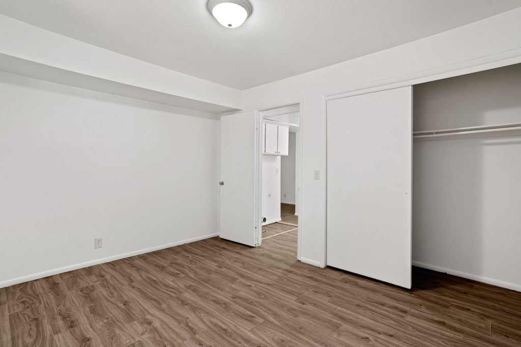 a living room with hardwood floors and white walls