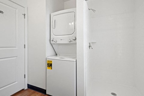 a white washer and dryer in a room with a white door