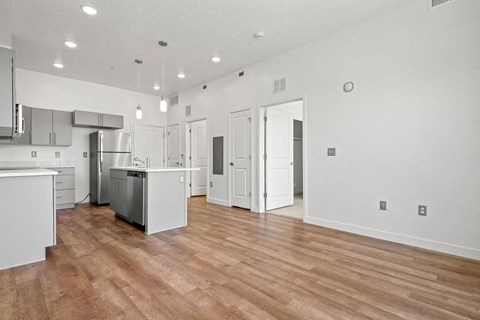 an open kitchen and living room with a hard wood floor