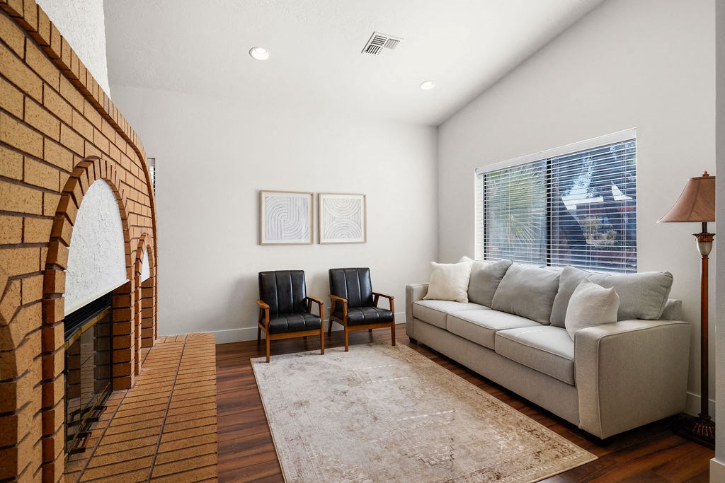 a living room with a couch and a brick fireplace