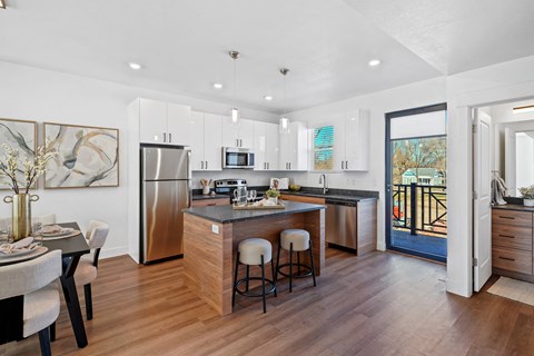 a kitchen with a large island and a stainless steel refrigerator