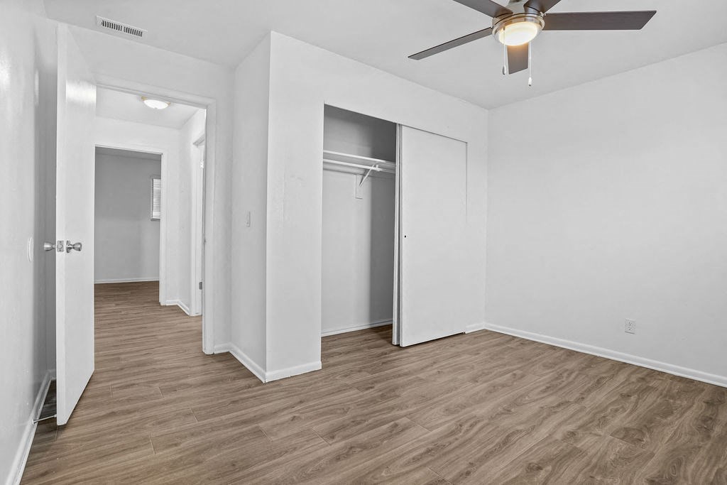 a living room with white walls and a ceiling fan