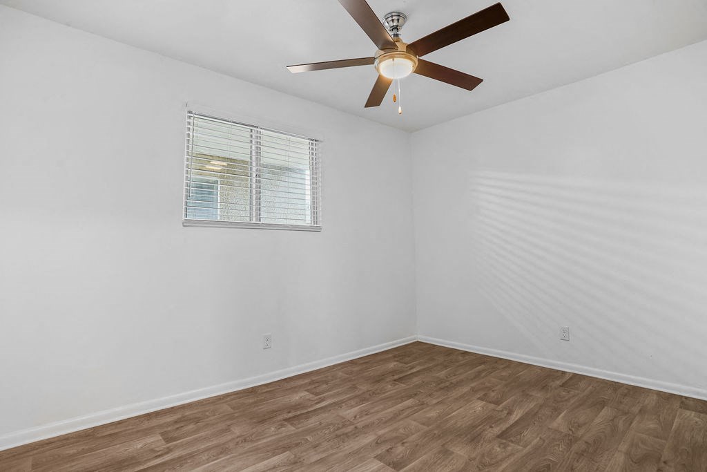 a bedroom with a ceiling fan and a window