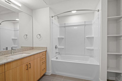 a bathroom with a tub and a sink and a mirror at SPARK Apartments, Salt Lake CIty, UT