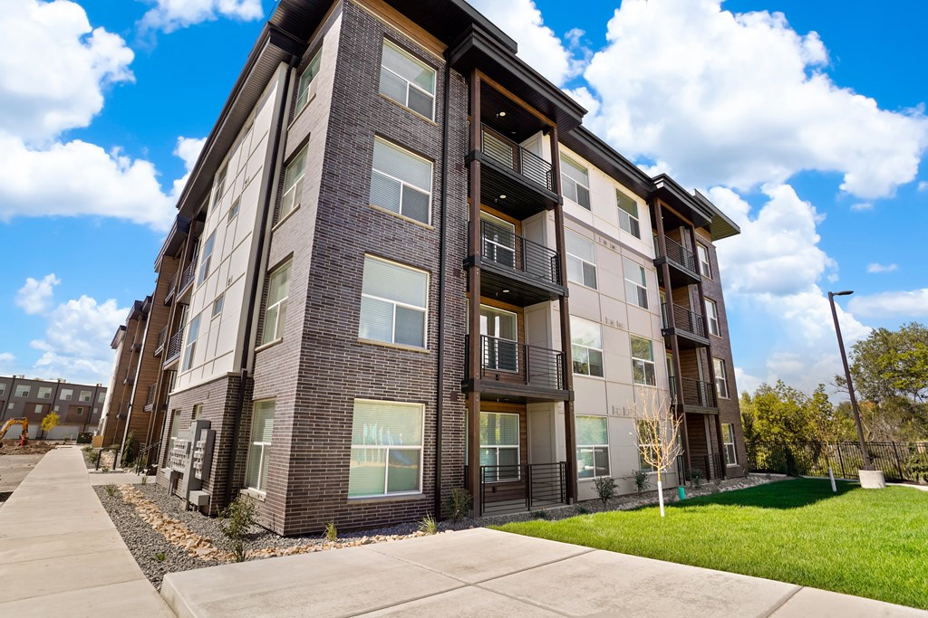 a brick apartment building with a sidewalk in front of it