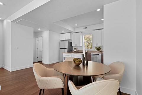 a living room with a table and chairs and a kitchen