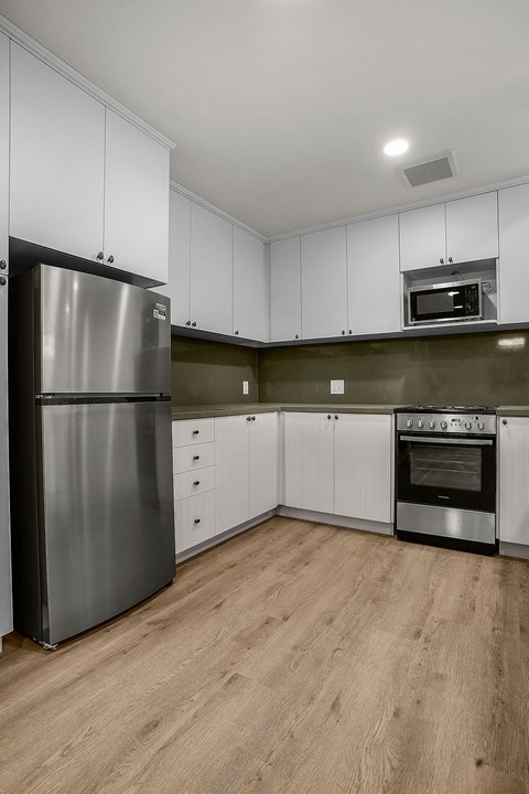 A kitchen with a stainless steel refrigerator and oven.