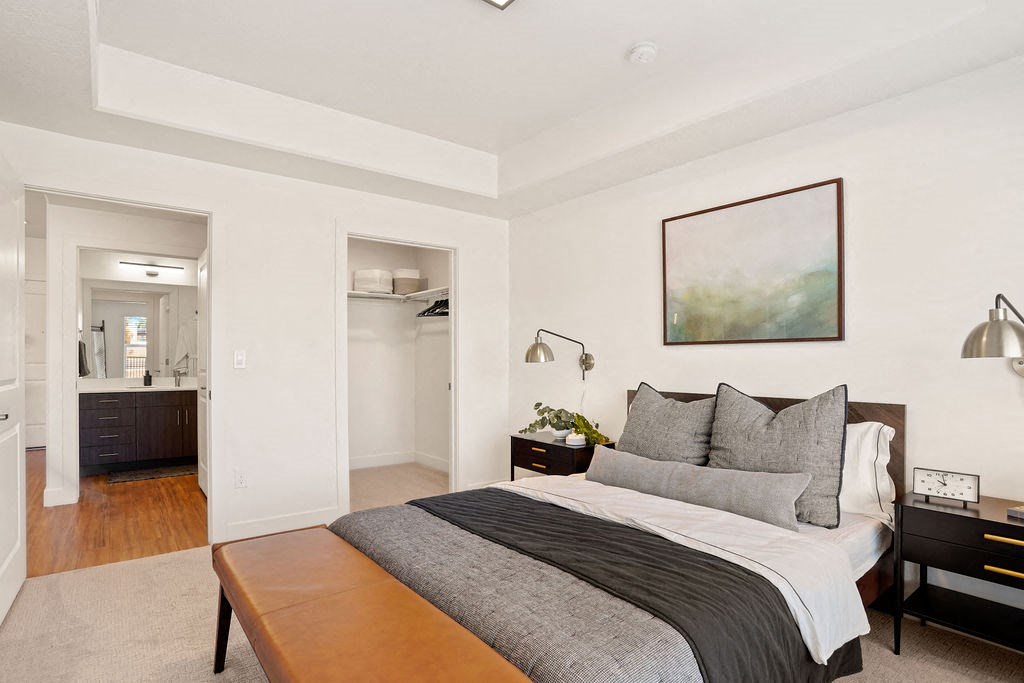 a bedroom with a large bed and a bathroom in the background