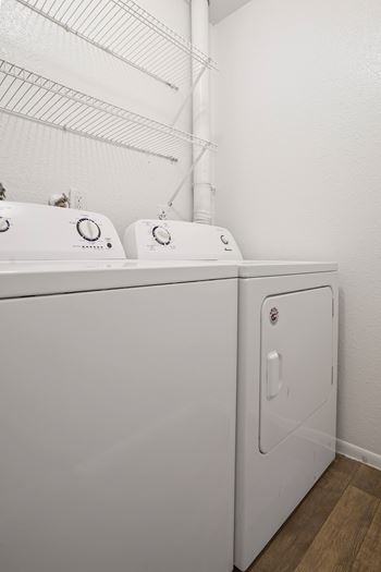 A white washing machine and dryer in a laundry room.