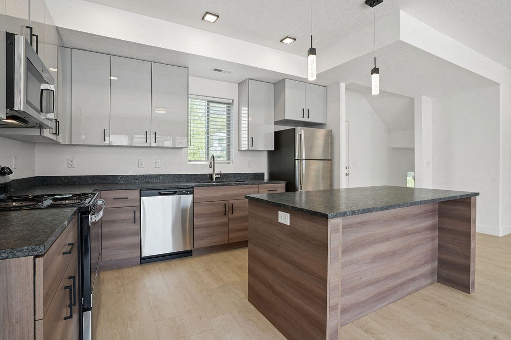 a large kitchen with an island and stainless steel appliances