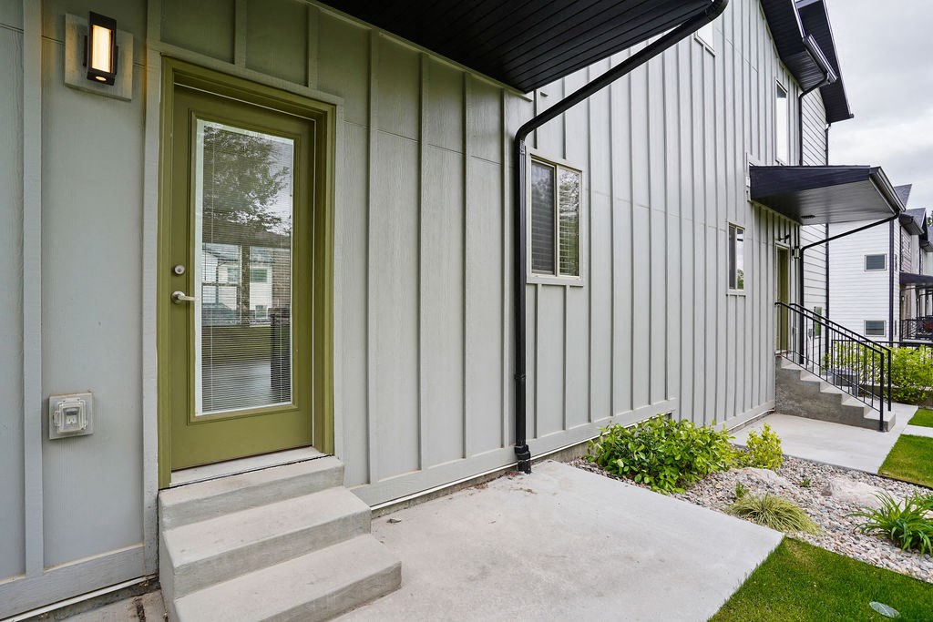 the front door of a home with steps and a sidewalk