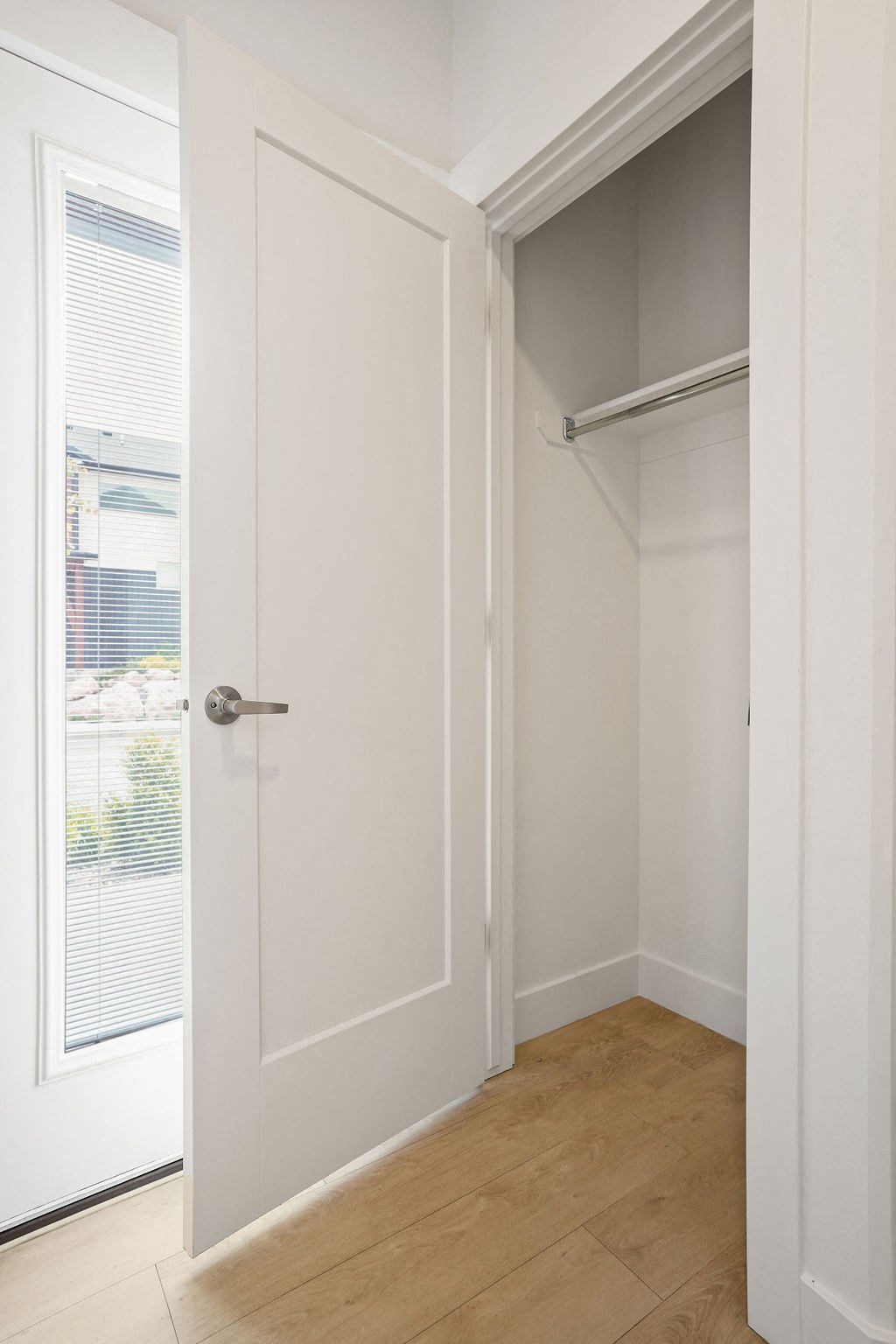 a closet with a white door and a window