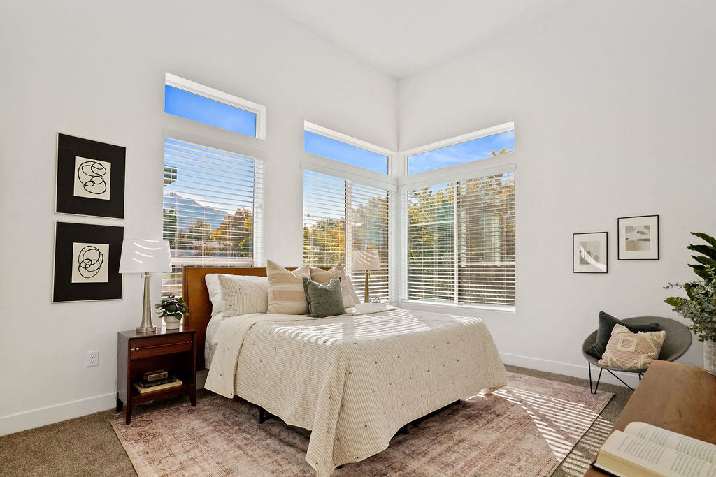 a bedroom with a bed and three windows