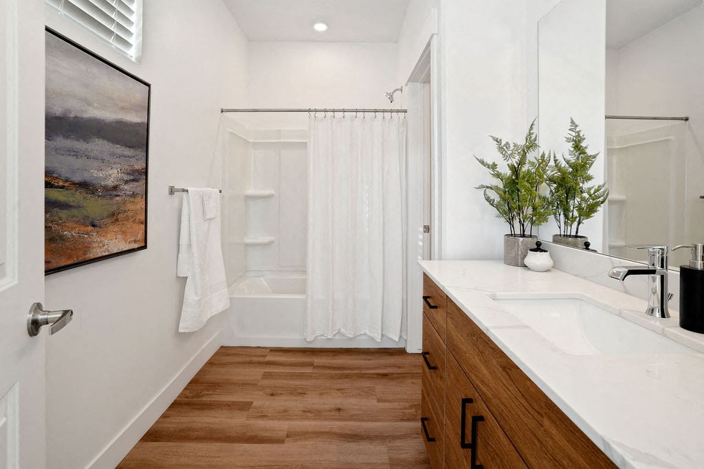 a bathroom with a sink and a shower and a mirror