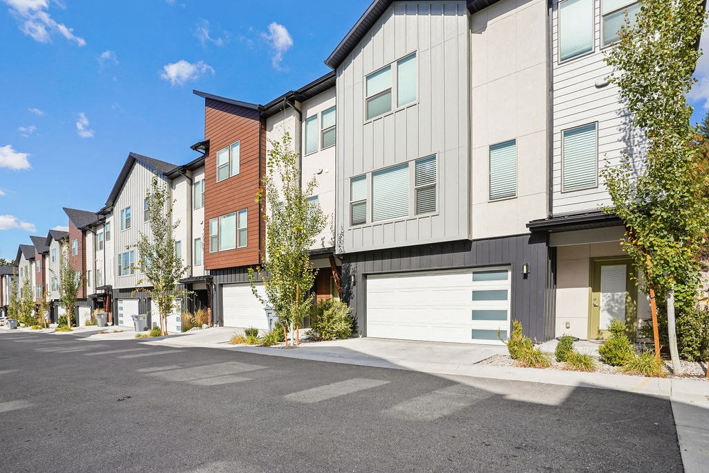 an empty parking lot in front of a row of apartment buildings