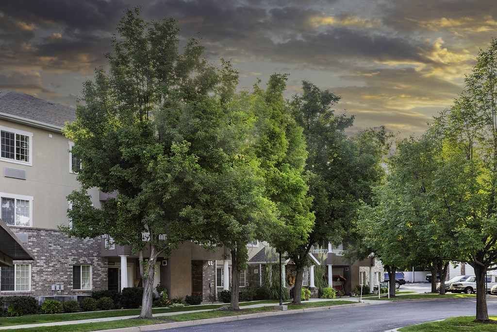 A row of houses with trees in front of them.