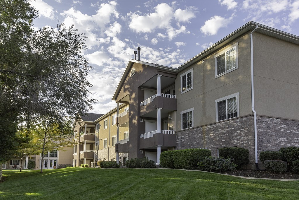 A large apartment complex with a green lawn in front.