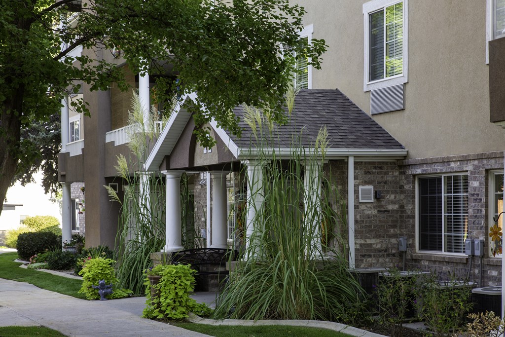 A house with a front porch and a tree in front.