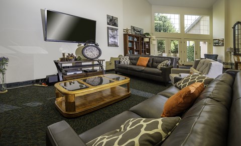 A living room with a large leather couch and a wooden coffee table.